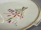 a plate with flowers painted on it on a table
