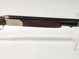 gros plan d'un fusil posé sur un support sur une surface blanche