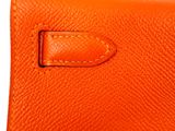 a close up of an orange purse with a brown handle