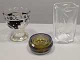trois vases en verre posés sur une table l'un à côté de l'autre