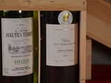 two bottles of wine in a wooden box on a table