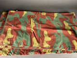 an orange, green and yellow camouflage cloth on a gray surface