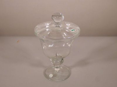 un pot en verre transparent avec un couvercle sur une table