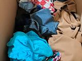 a cardboard box filled with clothes and clothing items
