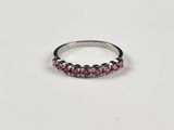 a silver ring with pink stones on a white background