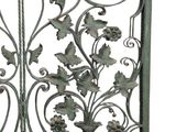 a metal gate that has flowers and leaves on it