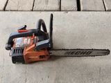 the chainsaw is sitting on the concrete on the sidewalk
