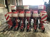 a row of red and white farm equipment in a barn