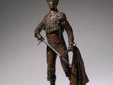 bronze figurine of a man with a sword and a cape