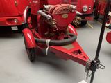 a red fire truck with a hose attached to it ' s side