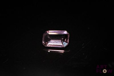 a close up of a purple diamond on a black surface