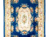 a blue and gold rug with a floral design on it