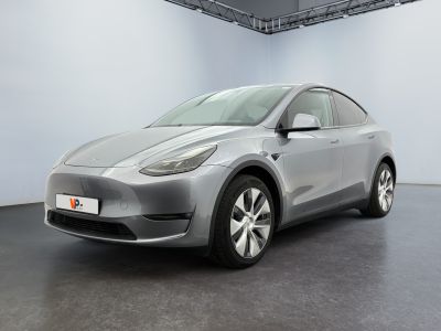 une Tesla Model Y argentée garée dans une pièce blanche