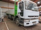 un camion vert et blanc garé à l'intérieur d'un bâtiment
