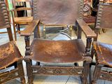 three wooden chairs with leather upholstered seats in a room