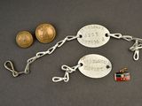 silver plated bracelet with two tags attached to it and a coin