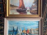 two paintings of sailboats on display in front of a painting easel