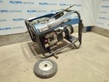 a small generator on the ground in front of a wall