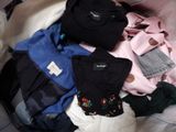 a pile of clothes that is on a bed
