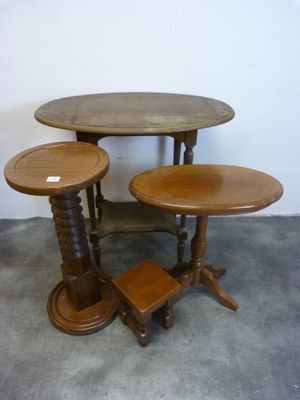 trois tables en bois posées sur un sol en béton, près d'un mur blanc