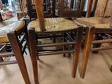 many wooden chairs that are stacked on top of each other