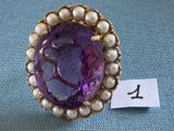 une image représentant une bague violette et blanche ornée de perles, sur fond bleu