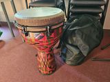 a drum sitting next to a bag on the floor