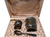 two cups and spoons in a box on a table