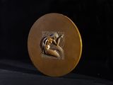 a gold medal with a picture of a woman on it