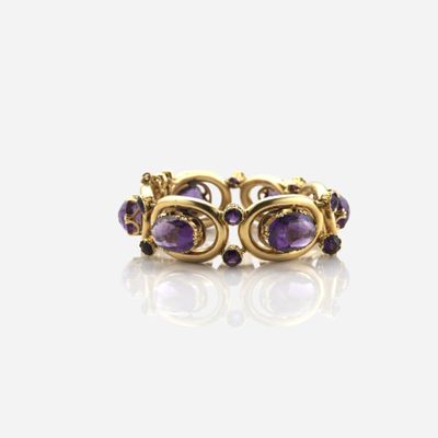 un gros plan d'une bague en or sertie de pierres violettes