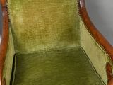 an old chair with a green velvet upholstered seat