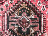 a close up of a red rug with a black and white design