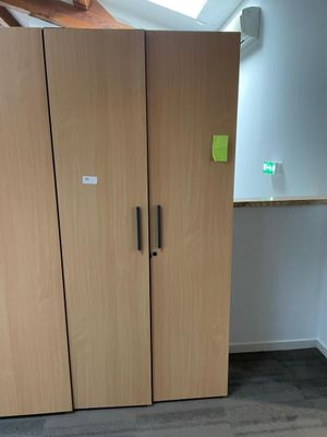 cabinets in a room with a skylight and a desk in the corner