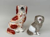 deux figurines de chiens assis l'une à côté de l'autre sur une surface blanche