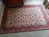 a rug on the floor of a room with a dresser in the background