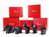 four black elephant figurines sitting in front of a red box