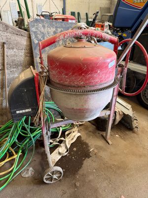 une borne d'incendie rouge posée dans un garage, à côté d'un tas de câbles