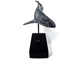 statue of a bird on a black stand against a white background