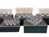 Plusieurs verres sont posés sur une boîte noire, sur un fond blanc.