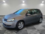 a silver volkswagen golf is parked in a room with a checkered floor