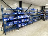 many shelves with blue bins on them in a warehouse