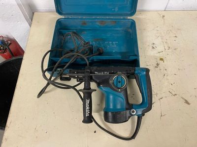 a blue drill sitting on top of a table next to a tool box