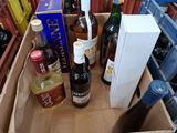 de nombreuses bouteilles d'alcool dans un carton posé par terre