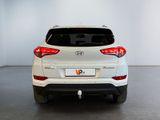 the rear end of a white suv parked in a white room