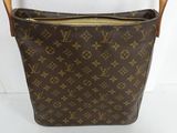 a close up of a brown louis vuitton bag on a white surface
