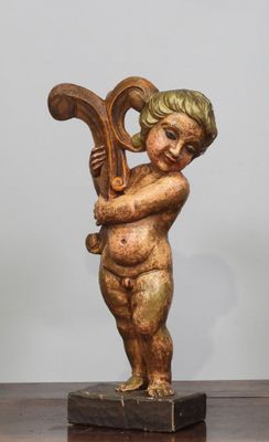 une statue représentant un enfant tenant une harpe posée sur une table