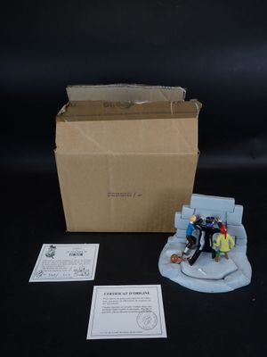 une boîte contenant une figurine représentant un groupe de personnes assises sur un canapé