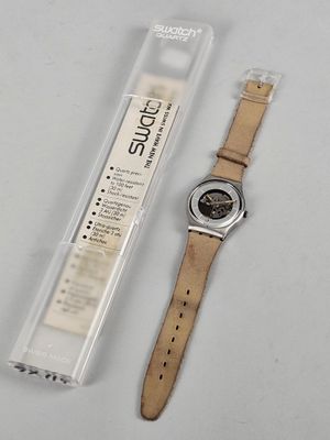 a watch that is laying on a table next to a package