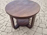 a round table on a brick patio with a wooden base