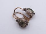 pair of silver and gold earrings with pearls on them on a white surface